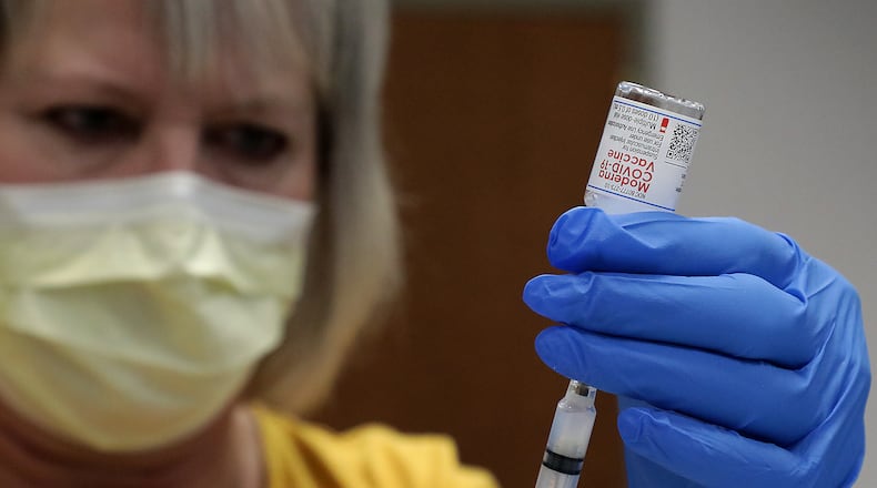 Nurse Lynn DiLoreto draws up a dose of teh Moderna COVID-19 vaccine Wednesday at the Champaign County vaccine distribution site at the Champaign County Government Center. BILL LACKEY/STAFF