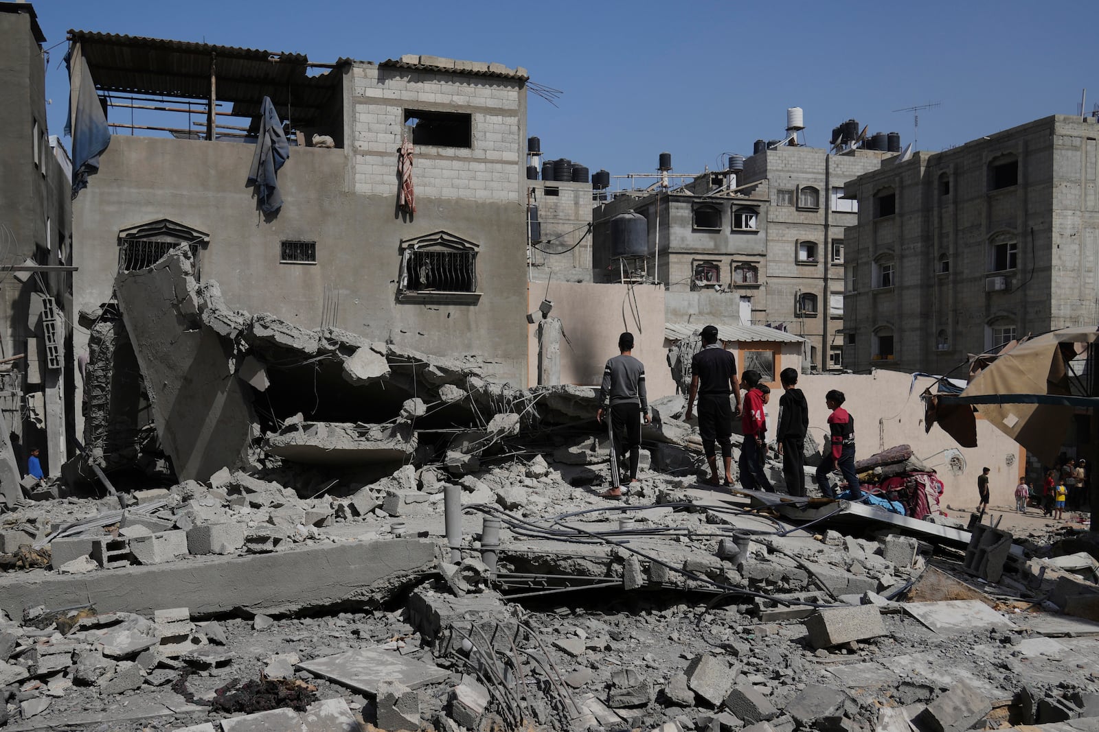 Palestinians look at a house targeted by an Israeli army strike in Khan Younis, Gaza Strip, Saturday, May 3, 2025. (AP Photo/Abdel Kareem Hana)