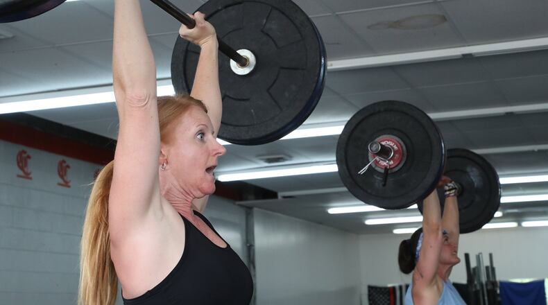 Julie Sasala, left, and the rest of the noon class at Champion City CrossFit were glad the gym on Upper Valley Pike was allowed to reopen Tuesday. BILL LACKEY/STAFF