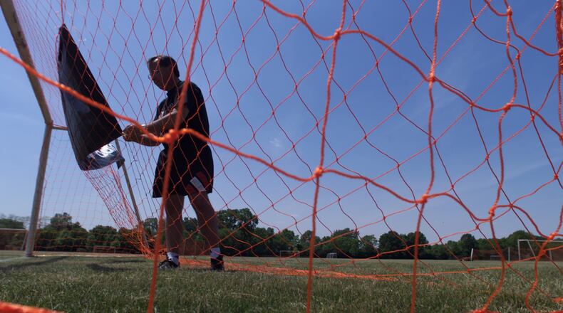 In 2005, Warrior Soccer Club coach George Dowling puts up sponsor adidas's sign on a goal net at Thomas Cloud Park for the adidas Warrior Classic Tournament. (Courtesy/Jim Witmer)