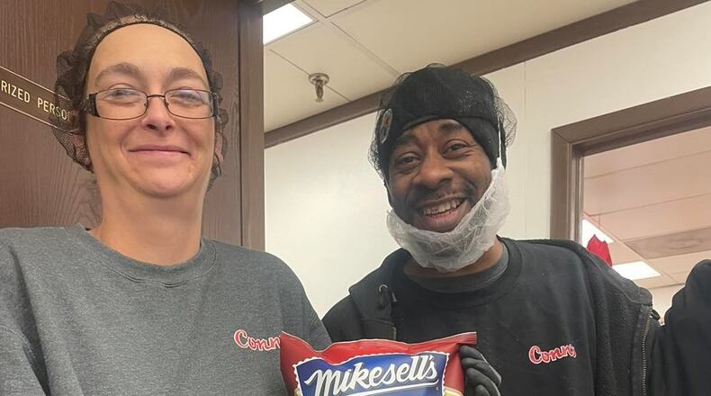 Conn's packing room Supervisor Tomorrow and head Fryer Technician Mel displaying the first Mikesell's bag of chips off the line at Conn’s Zanesville plant. Conn's Facebook photo
