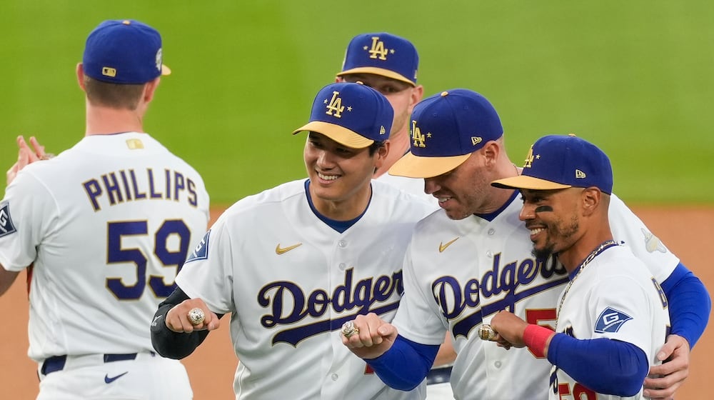 Los Angeles Dodgers Shohei Ohtani, Freddie Freeman and Mookie Betts pose with their rings during a World Series Champion ring ceremony prior to a baseball game against the Arizona Diamondbacks in Los Angeles, Friday, March 27, 2026. (AP Photo/Caroline Brehman)