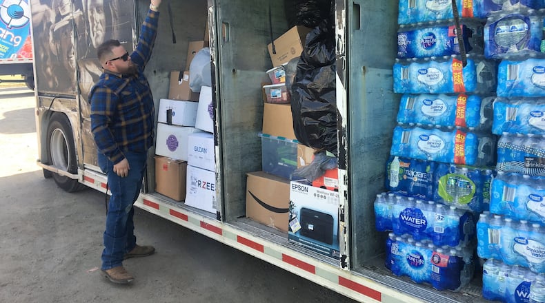 Kyle Greene closes a semi trailer filled with donated water, food, clothes and other items that will be distributed to those impacted by tornado devastation in Kentucky. Hasan Karim/ Staff