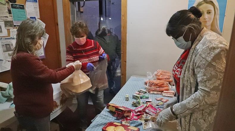 Several events are scheduled in Clark and Champaign counties through the Thanksgiving holiday, including the Springfield Soup Kitchen's tradition and Italian Thanksgiving dinners. A few years ago, volunteers give out over 300 Thanksgiving meals through a doorway at the Springfield Soup Kitchen. FILE/BILL LACKEY/STAFF