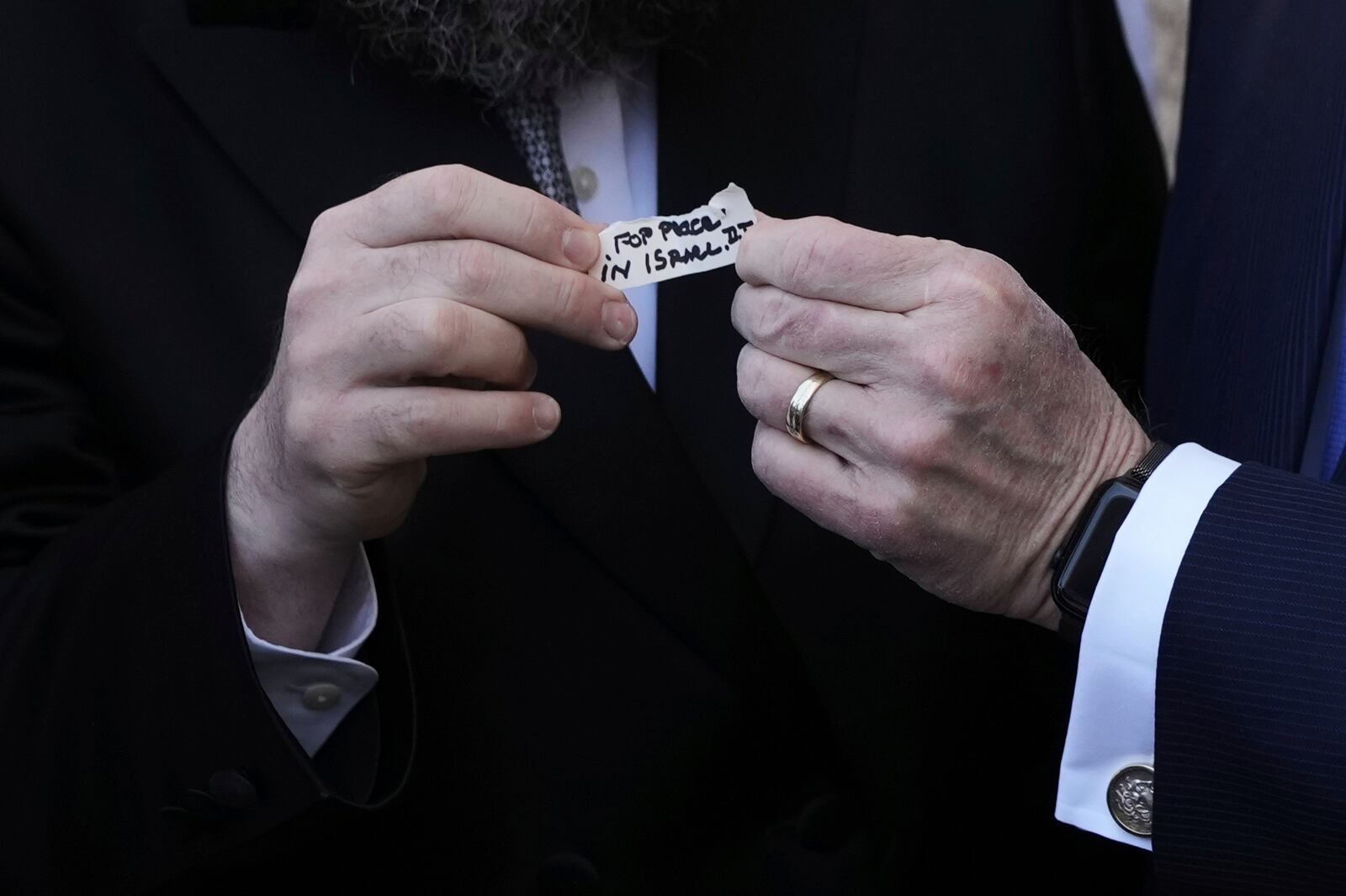 The US ambassador to Israel Mike Huckabee holds a note given to him from US President Donald Trump to be placed in the cracks of the Western Wall, the holiest site where Jews can pray, in the Old City of Jerusalem, Friday, April 18, 2025. (AP Photo/Leo Correa)