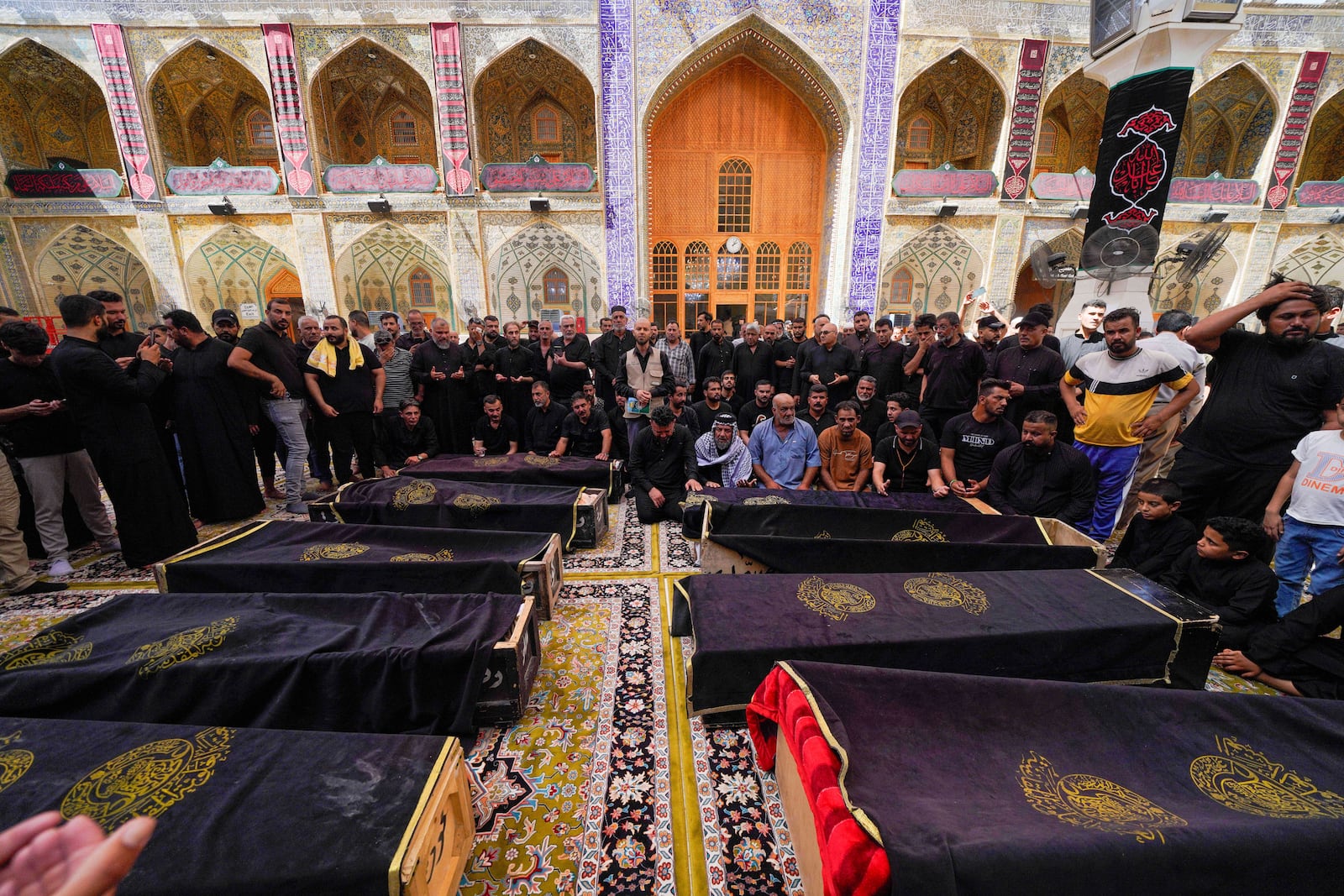 Mourners attend the funeral of victims who died in a fire at a shopping center in Kut, at the shrine of Imam Ali in Najaf, Iraq, Thursday, July 17, 2025. (AP Photo/Anmar Khalil)