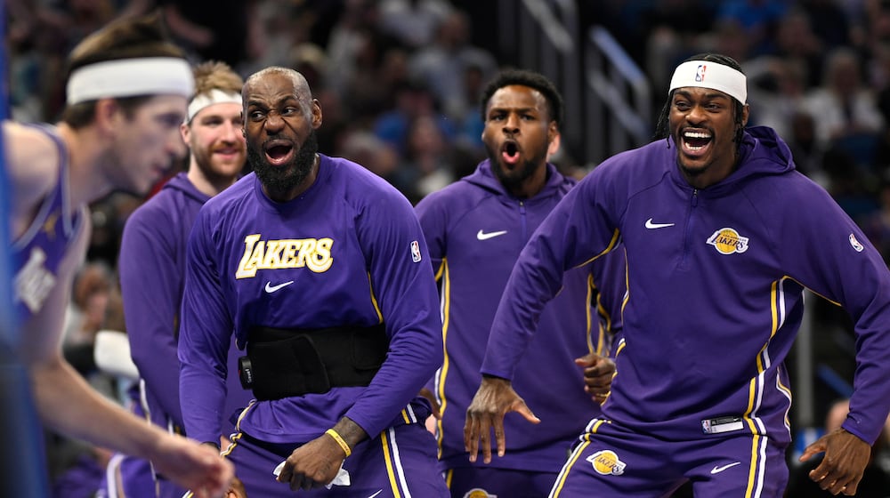 Los Angeles Lakers forward LeBron James, second from front right, and forward Jarred Vanderbilt, right, react after a dunk by guard Austin Reaves, left, during the first half of an NBA basketball game against the Orlando Magic, Saturday, March 21, 2026, in Orlando, Fla. (AP Photo/Phelan M. Ebenhack)