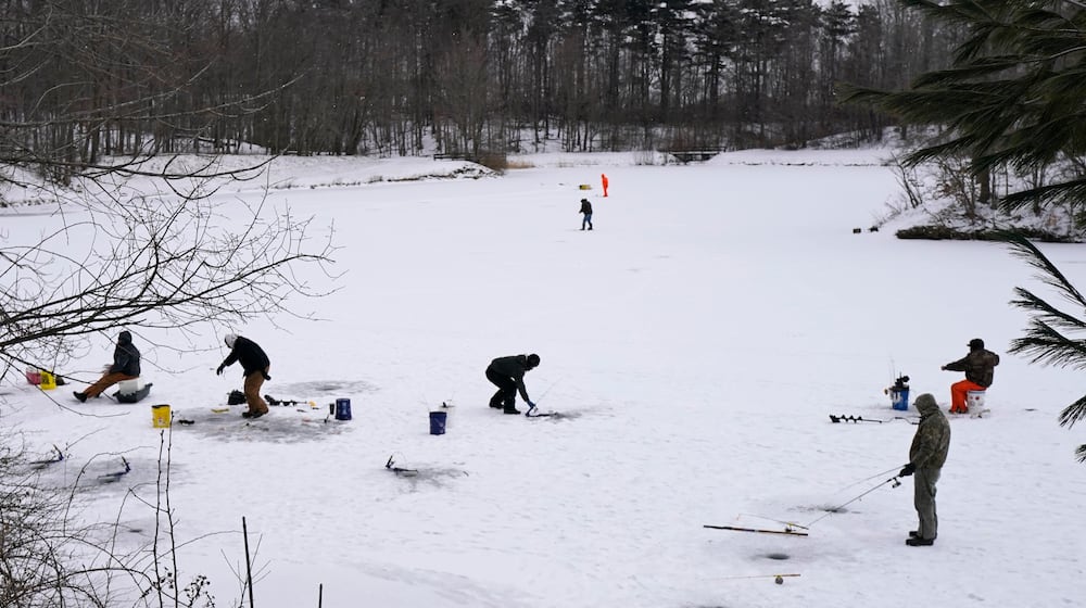Ice fishermen take advantage of the cold weather as they fish on Shadow Lake, Friday, Jan. 29, 2021, in Solon, Ohio. (AP Photo/Tony Dejak)