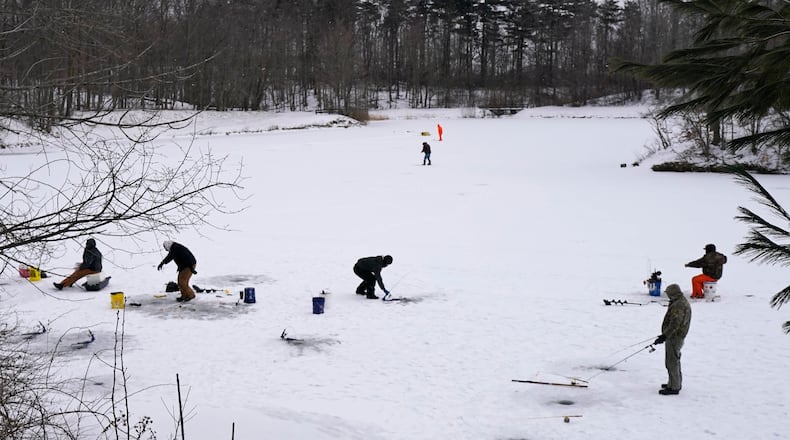 Ice fishermen take advantage of the cold weather as they fish on Shadow Lake, Friday, Jan. 29, 2021, in Solon, Ohio. (AP Photo/Tony Dejak)