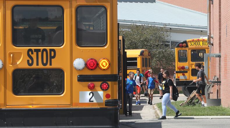 Students board school bus outside Shawnee High School. BILL LACKEY/STAFF