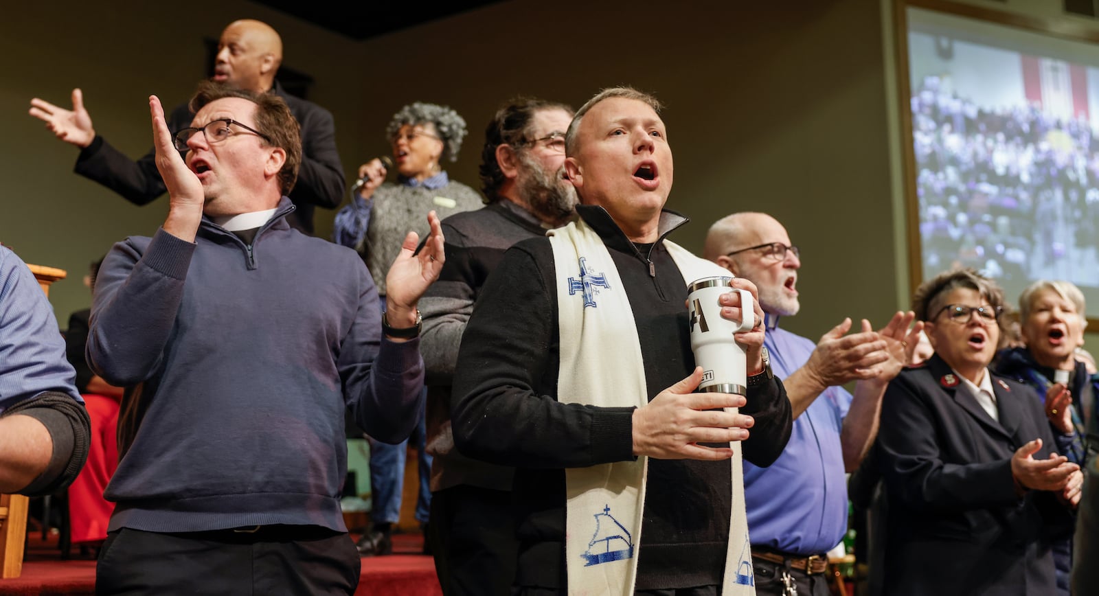 Faith leaders praise and sing along to Elevation Worship's "Trust in God" during Here We Stand: Faith Leaders for Immigration Justice & Family Unity at St. John Missionary Baptist Church on Monday, Feb. 2, 2026, in Springfield. Pastors and community members gathered to pray and call for the extension of Temporary Protected Status which is scheduled to expire on Tuesday, Feb. 3, 2026. JOSEPH COOKE/STAFF