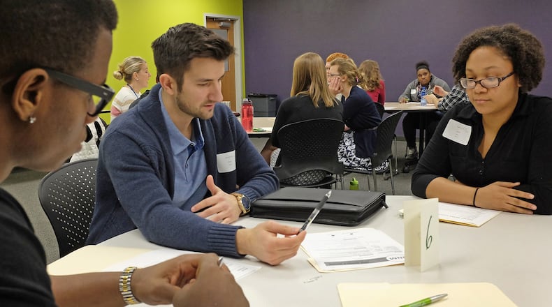 High School students Malik Young, left, and Jace Moore listen as Steve Newell critiques their resume Thursday during Internship Day at the Career Cennect Center. Bill Lackey/Staff
