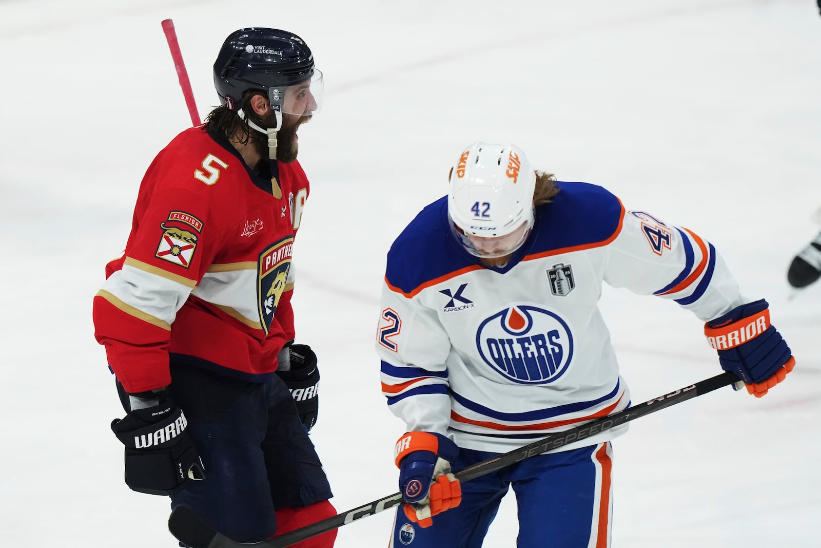 Florida Panthers' Aaron Ekblad (5) celebrates his goal as Edmonton Oilers' Kasperi Kapanen (42) skates past during the third period in Game 3 of the NHL hockey Stanley Cup finals in Sunrise, Fla., Monday, June 9, 2025. (Nathan Denette/The Canadian Press via AP)