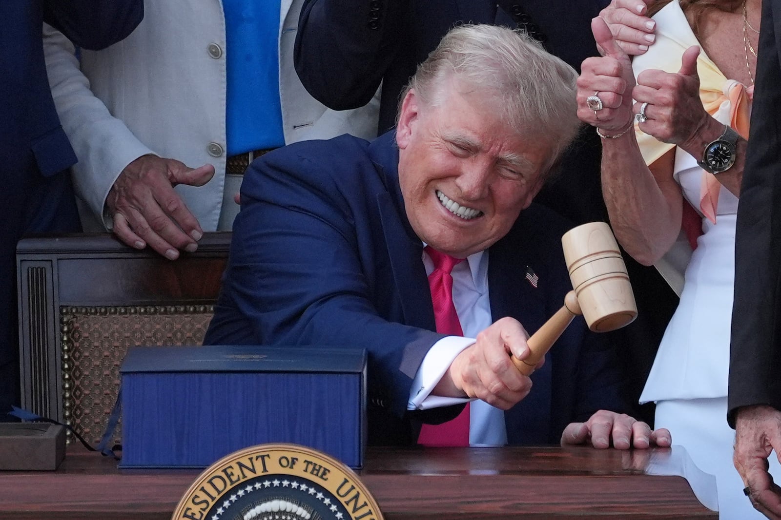 President Donald Trump bangs a gavel presented to him by House Speaker Mike Johnson of La., after he signed his signature bill of tax breaks and spending cuts at the White House, Friday, July 4, 2025, in Washington. (AP Photo/Evan Vucci)