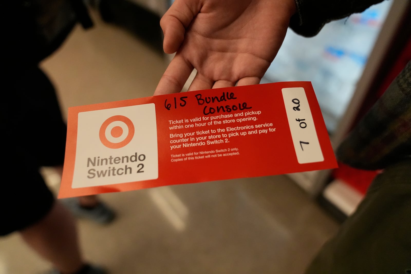 A customer presents a pre-order ticket for the new Nintendo Switch 2 video game console at a Target store on Thursday, June 5, 2025 in Chicago. (AP Photo/Kiichiro Sato)