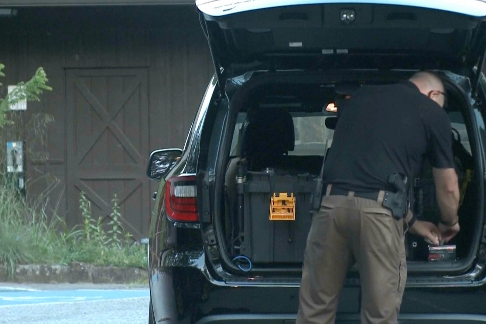 In this image made from video taken on Saturday, July 26, 2025, provided by KHBS/KHOG, law enforcement officers investigate the deaths of a couple who were attacked while on a wooded walking trail with their two young daughters at Devil's Den State Park in West Fort, Ark. (KHBS/KHOG via AP)