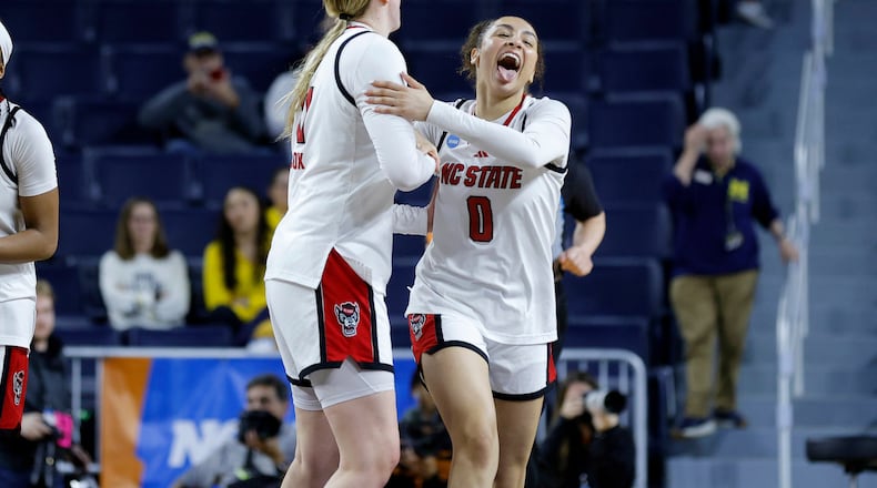North Carolina State guard Devyn Quigley (0) and forward Maddie Cox, center left, celebrate after defeating Tennessee in the first round of the NCAA college basketball tournament, Friday, March 20, 2026, in Ann Arbor, Mich. (AP Photo/Al Goldis)