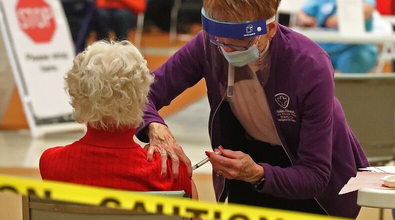 Judy Livingston gets a senior a COVID vaccine shot by a Clark County Combined Health District employee on Tuesday. Seven providers in the county received about 1,800 doses of the COVID-19 vaccine this week. All of those doses will be used on residents ages 80 and up. BILL LACKEY/STAFF