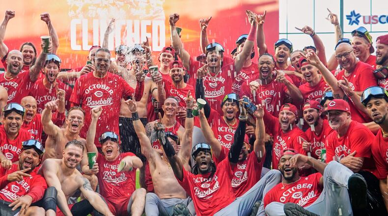 The Cincinnati Reds celebrate as they take a team photo after making it into the playoffs after a baseball game against the Milwaukee Brewers Sunday, Sept. 28, 2025, in Milwaukee. (AP Photo/Morry Gash)