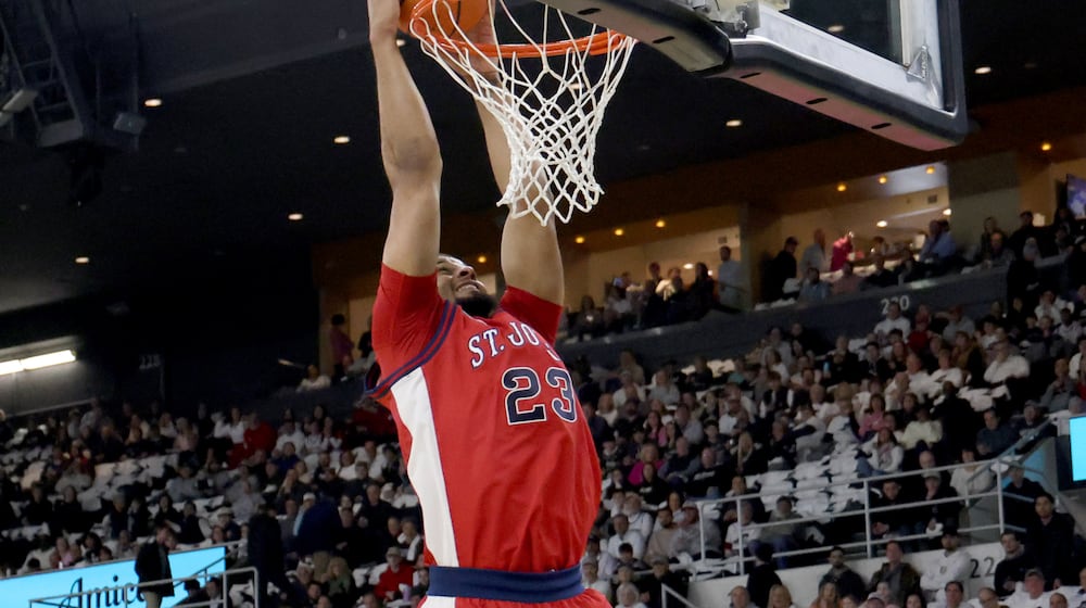 St. John's forward Bryce Hopkins (23) dunks the ball during the first half of an NCAA college basketball game against Providence, Saturday, Feb. 14, 2026, in Providence, R.I. (AP Photo/Mark Stockwell)