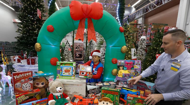The Beavercreek Walmart is gearing up for the holiday season as Suzie Becchetti, a store associate, and Sean Epsy, store manager of the Moraine Walmart, set up a Christmas display. MARSHALL GORBY\STAFF
