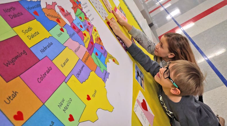 Milo Wiedeke and Khali Jordan, second graders at Lagonda Elementary School, point out some of their favorite Valentines Day cards that their class has recieved from people around the country Tuesday, Feb. 11, 2025. BILL LACKEY/STAFF
