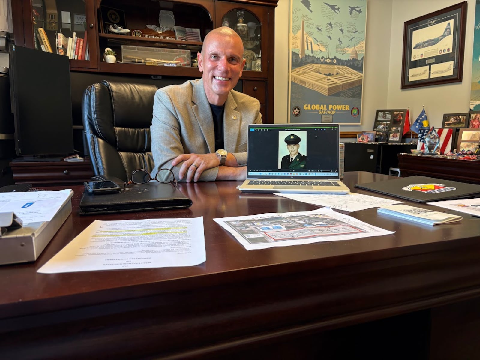 Col. Matthew Muha, deputy commander of the 445th Airlift Wing at Wright-Patterson Air Force Base, with a U.S. Army basic training photograph of his father, Thomas, who served during the Vietnam War. Muha is also director of the Autonomy Capability (ACT3) Team, at the Air Force Research Laboratory, also at Wright-Patterson. THOMAS GNAU/STAFF