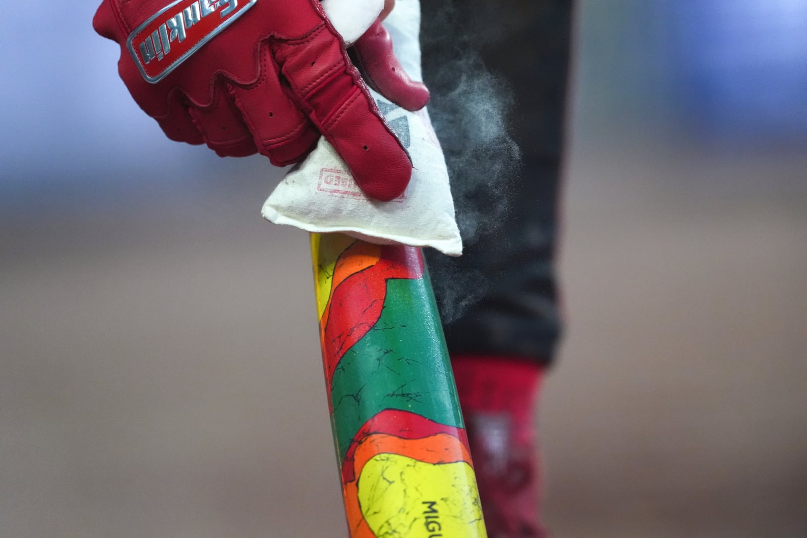 Cincinnati Reds' Miguel Andujar prepares a special bat for Players' Weekend in the fourth inning of a baseball game against the Milwaukee Brewers, Friday, Aug. 15, 2025, in Cincinnati. (AP Photo/Kareem Elgazzar)