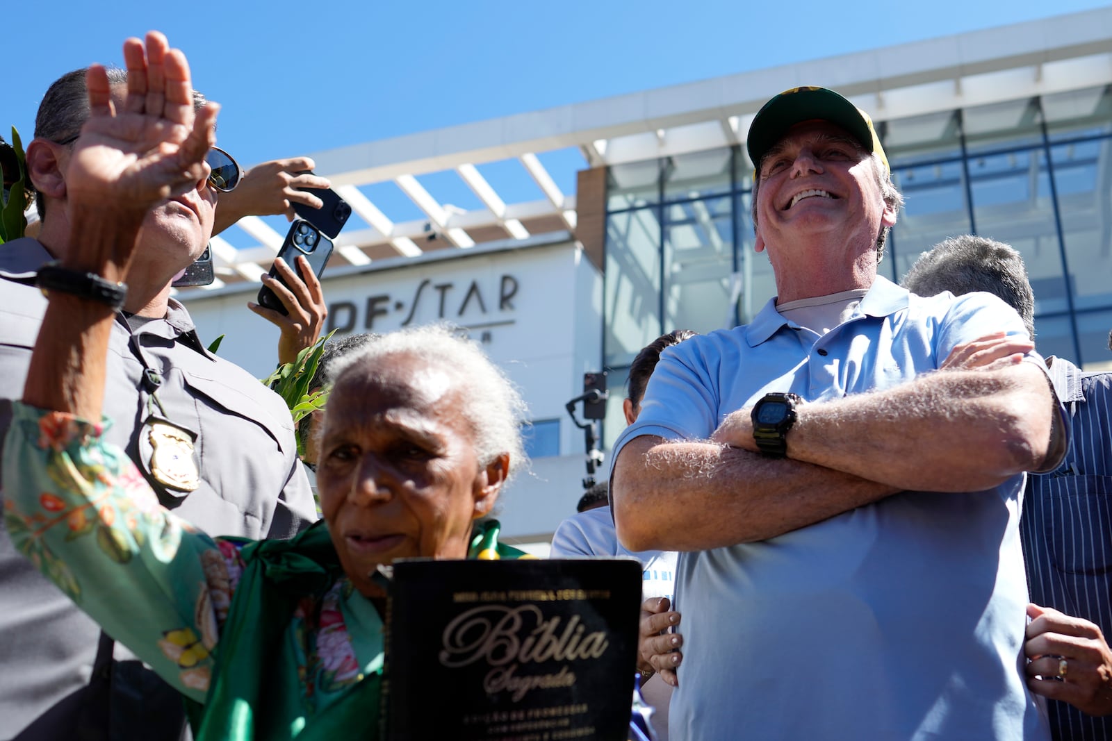 Former President Jair Bolsonaro receives a supporter's prayers as he leaves the hospital after a weeks-long surgical stay, in Brasilia, Brazil, Sunday, May 4, 2025. (AP Photo/Eraldo Peres)
