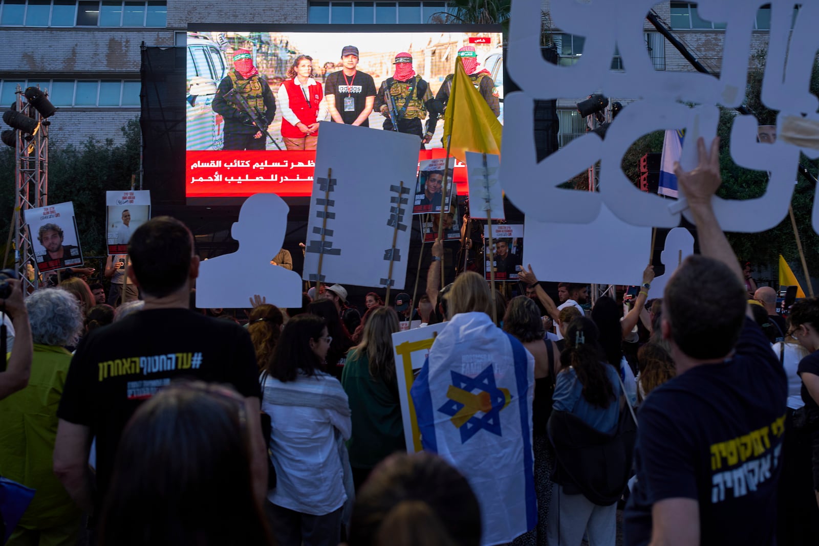 People watch a live broadcast of Israeli-American soldier Edan Alexander as he is released from Hamas captivity in Gaza, at a plaza known as the hostages square in Tel Aviv, Monday, May 12, 2025. Alexander was abducted during the Hamas-led attack on his base on October 7, 2023. (AP Photo/Oded Balilty)