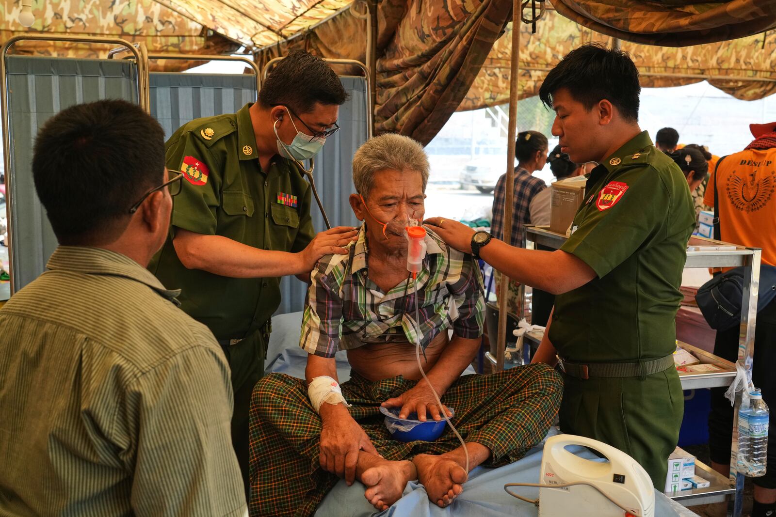 Military medical volunteers give treatments to a patient at their make-shift tent after last week's earthquake in Naypyitaw, Myanmar, Friday, April 4, 2025. (AP Photo)