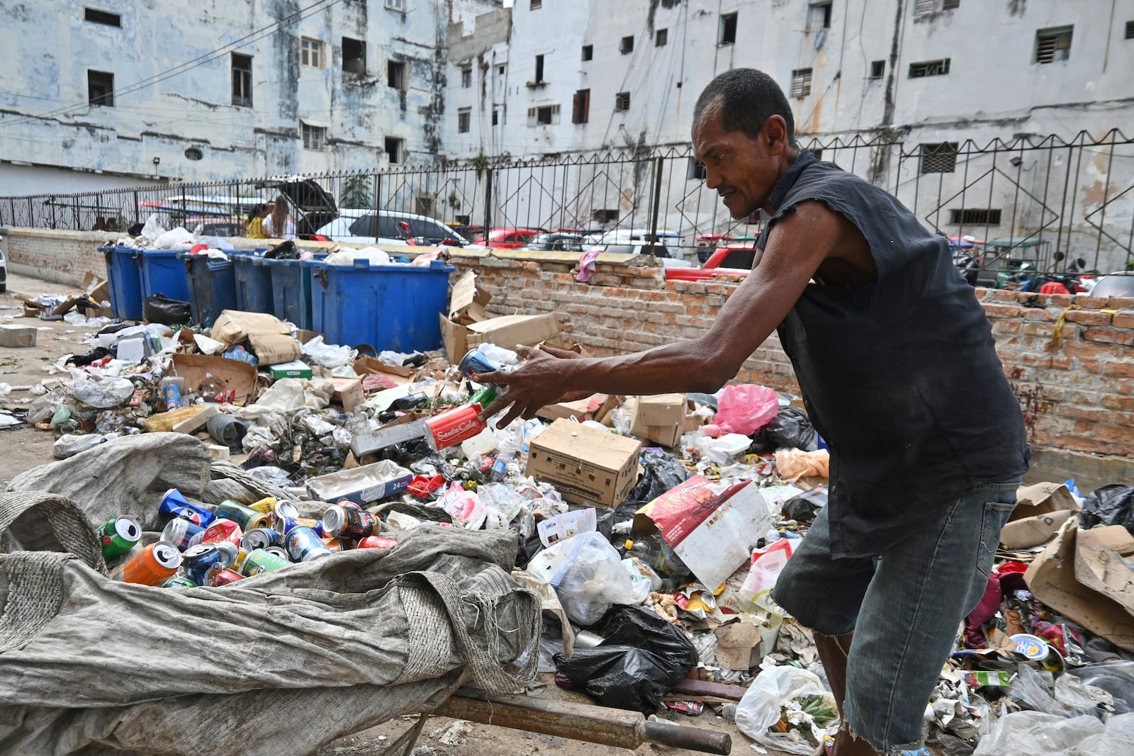 A man culls through garbage collecting aluminium cans for recycling, in Havana, Cuba, Tuesday, July 15, 2025. (AP Photo/Jorge Luis Baños)