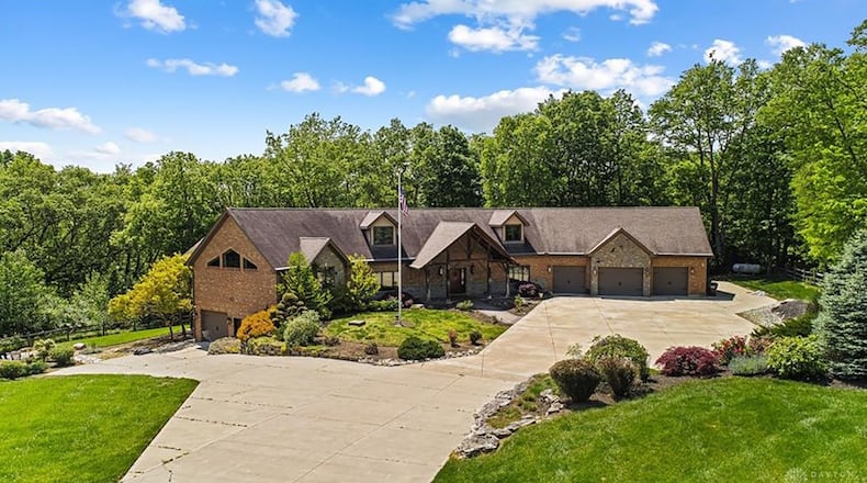 The front of the home has a three car attached garage on the main level and an additional two car on the basement level. It has a covered entry with wood beams and an extended driveway with heavy landscaping including a waterfall.