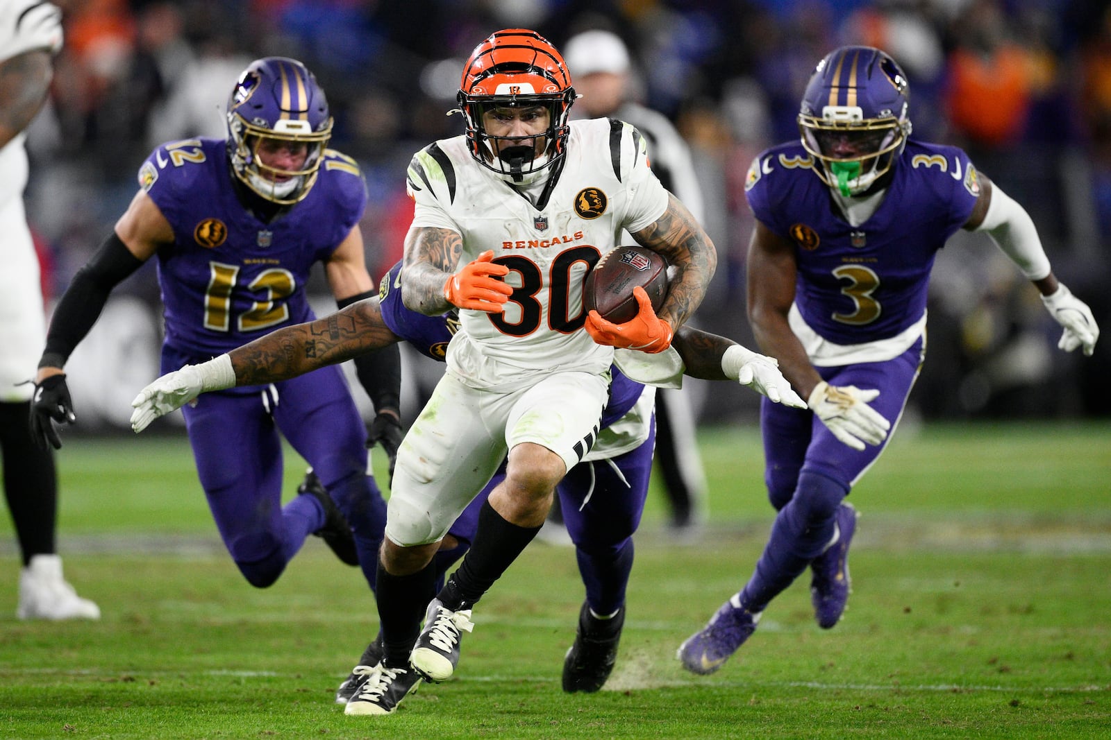 Cincinnati Bengals running back Chase Brown (30) runs with the all as Baltimore Ravens safety Alohi Gilman (12), linebacker Mike Green (45) and cornerback Chidobe Awuzie (3) give chase during the second half of an NFL football game, Thursday, Nov. 27, 2025, in Baltimore. (AP Photo/Nick Wass)