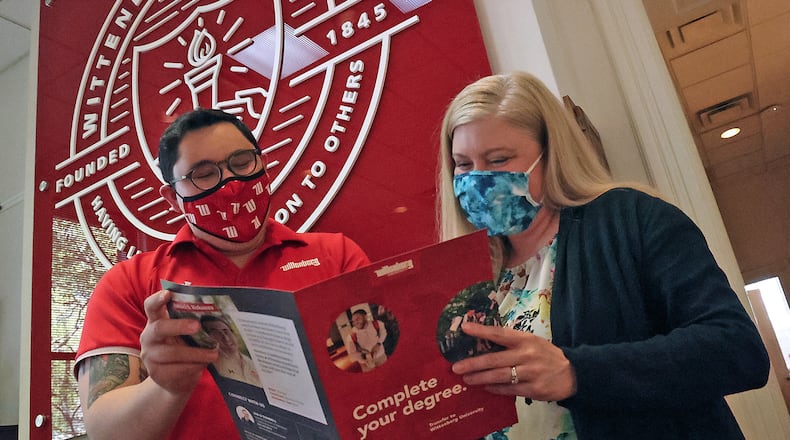 Wittenberg University and Clark State College show spring enrollment declines, which matches national trends. Here, Ian O'Donnell, assistant director of Admissions, and Carola Thorson, vice president of enrollment management, look over a booklet about transferring from one school to another. BILL LACKEY/STAFF
