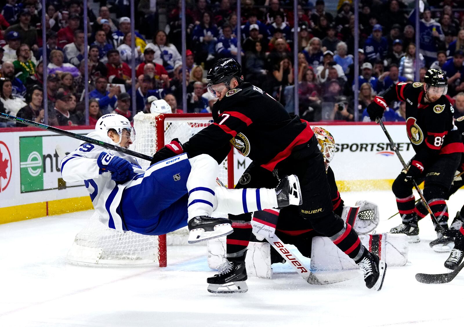 Ottawa Senators' Brady Tkachuk (7) knocks Toronto Maple Leafs' Pontus Holmberg (29) off his skates, after Holmberg's shot on goaltender Linus Ullmark (35), during third period NHL playoff action in Ottawa, on Saturday, April 26, 2025. (Adrian Wyld/The Canadian Press via AP)