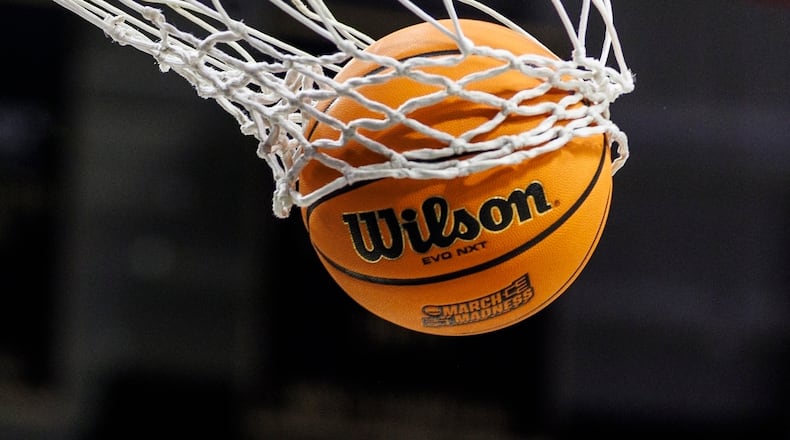 FILE - A basketball with a March Madness logo is seen going through a net prior to a second round of the NCAA college basketball tournament between Notre Dame and Michigan, March 23, 2025, in South Bend, Ind. (AP Photo/John Mersits, File)