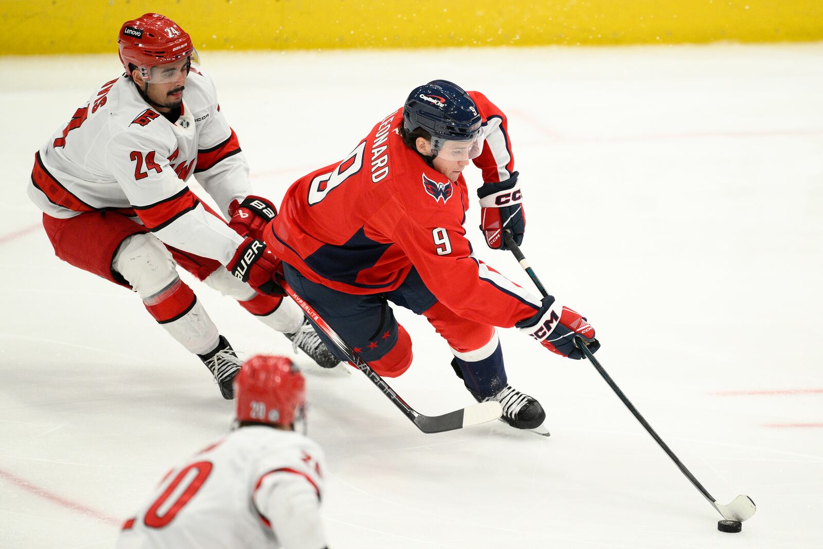 Washington Capitals right wing Ryan Leonard (9) skates with the puck past Carolina Hurricanes center Seth Jarvis (24) during the third period of an NHL hockey game, Thursday, April 10, 2025, in Washington. (AP Photo/Nick Wass)