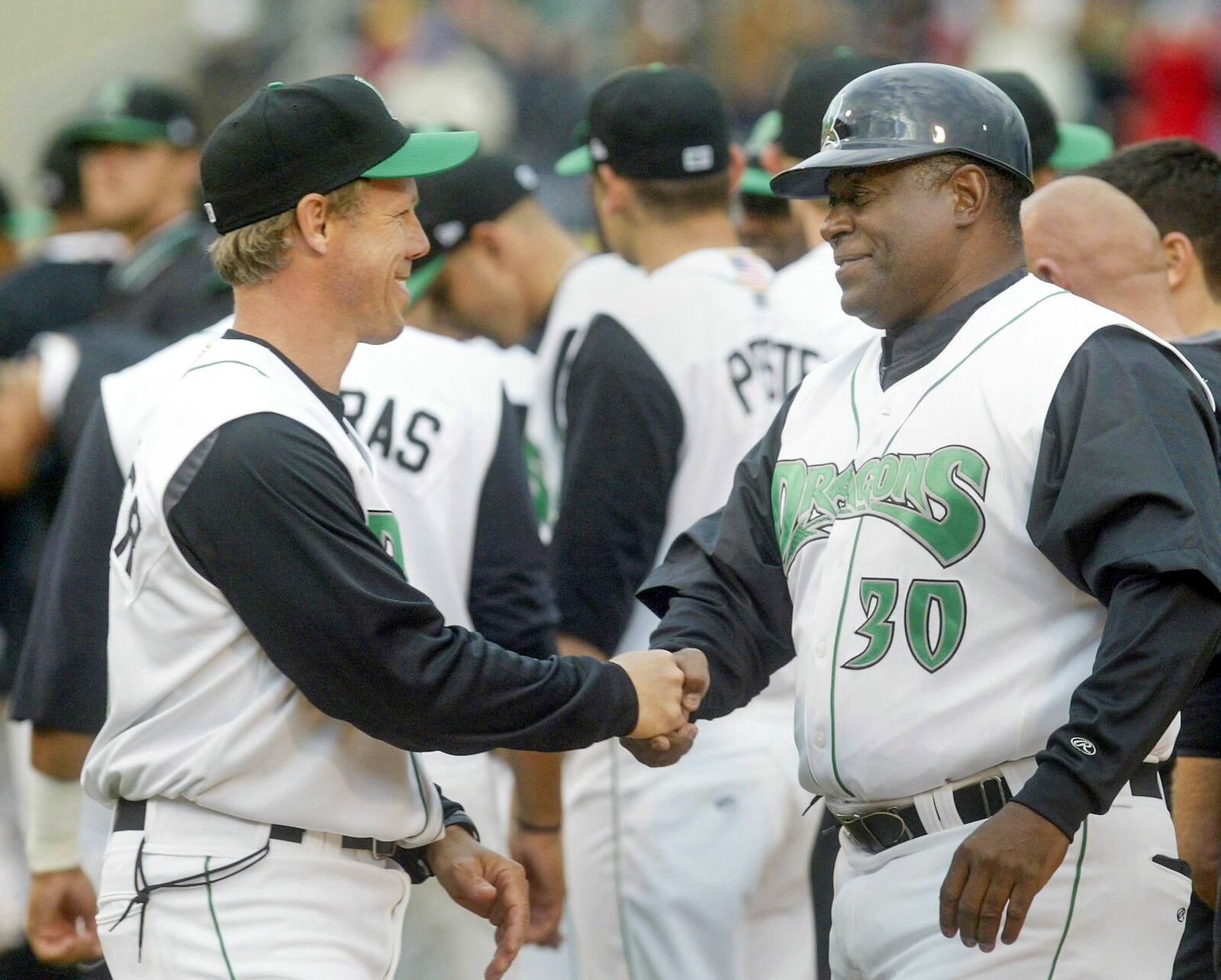 Todd Benzinger, left, the Dayton Dragons' manager, shakes hands with hitting coach Ken Griffey, Sr. before their 2010 season opener against the Lansing Lugnuts on Thursday, April 8, at Fifth Third Field.