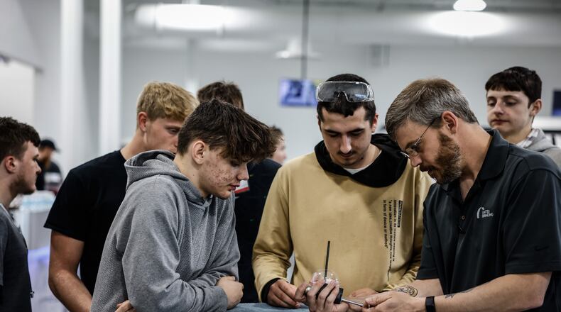 T.J. Vieira, right, a software technician for United Grinding in Miamisburg demonstrates how to measure the size of a bore. United Grinding held a manufacturing day in 2022 at the plant hosting seven school and over 200 high school students to learn about career paths in manufacturing. JIM NOELKER/STAFF