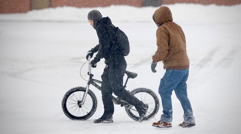 Two people brave the cold and the snow to get to the grocery store on Main Street in Springfield early Monday morning, Jan. 6, 2025. MARSHALL GORBY / STAFF