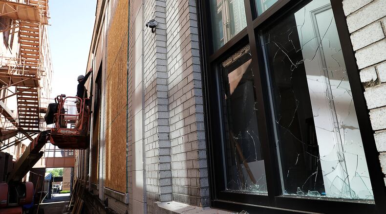 Windows at a business along Main Street are boarded up Monday morning. They were broken during Sunday night's disturbance in downtown Springfield. BILL LACKEY/STAFF