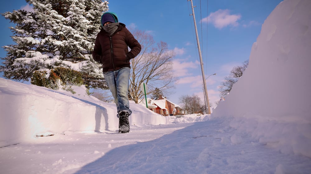 Matt Johnson takes a walk down Harding Road in Springfield, one of the few areas where sidewalks were cleared of snow as of Monday afternoon, Jan. 26, 2026. MARSHALL GORBY / CONTRIBUTED