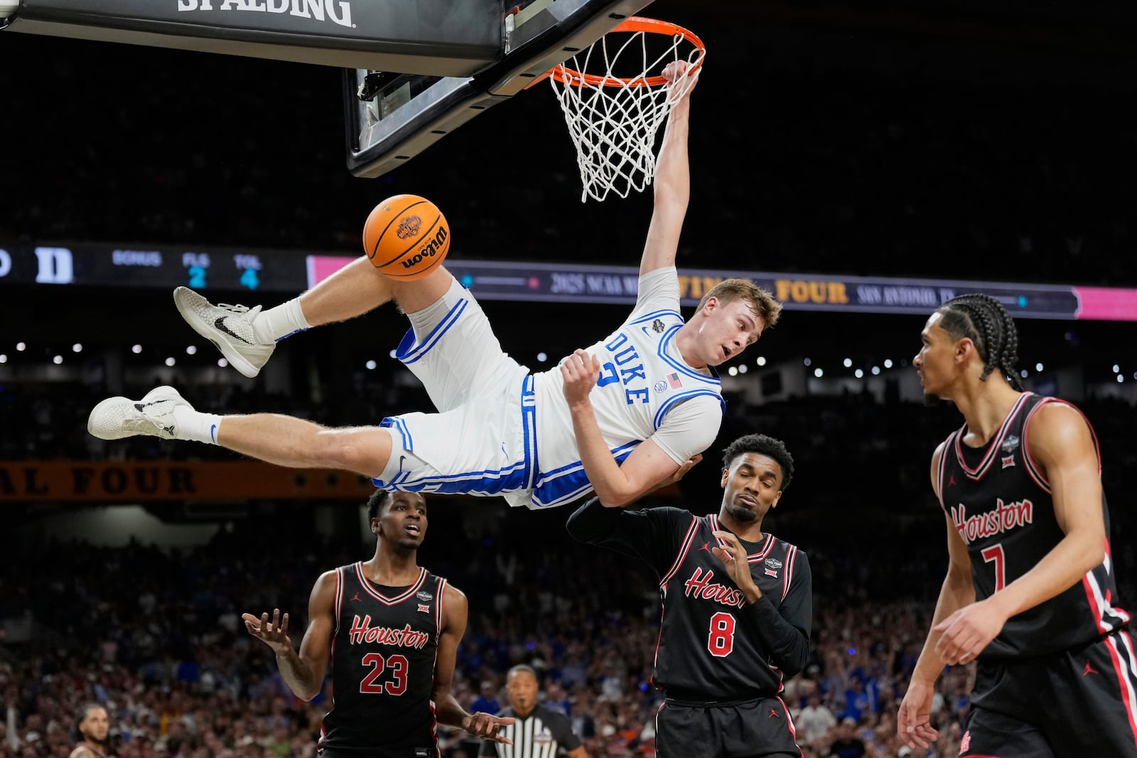 FILE - Duke's Cooper Flagg (2) looks back after dunking the ball as Houston's Terrance Arceneaux (23), Mylik Wilson (8) and Milos Uzan (7) watch during the first half in the national semifinals at the Final Four of the NCAA college basketball tournament, Saturday, April 5, 2025, in San Antonio. (AP Photo/Eric Gay, File)