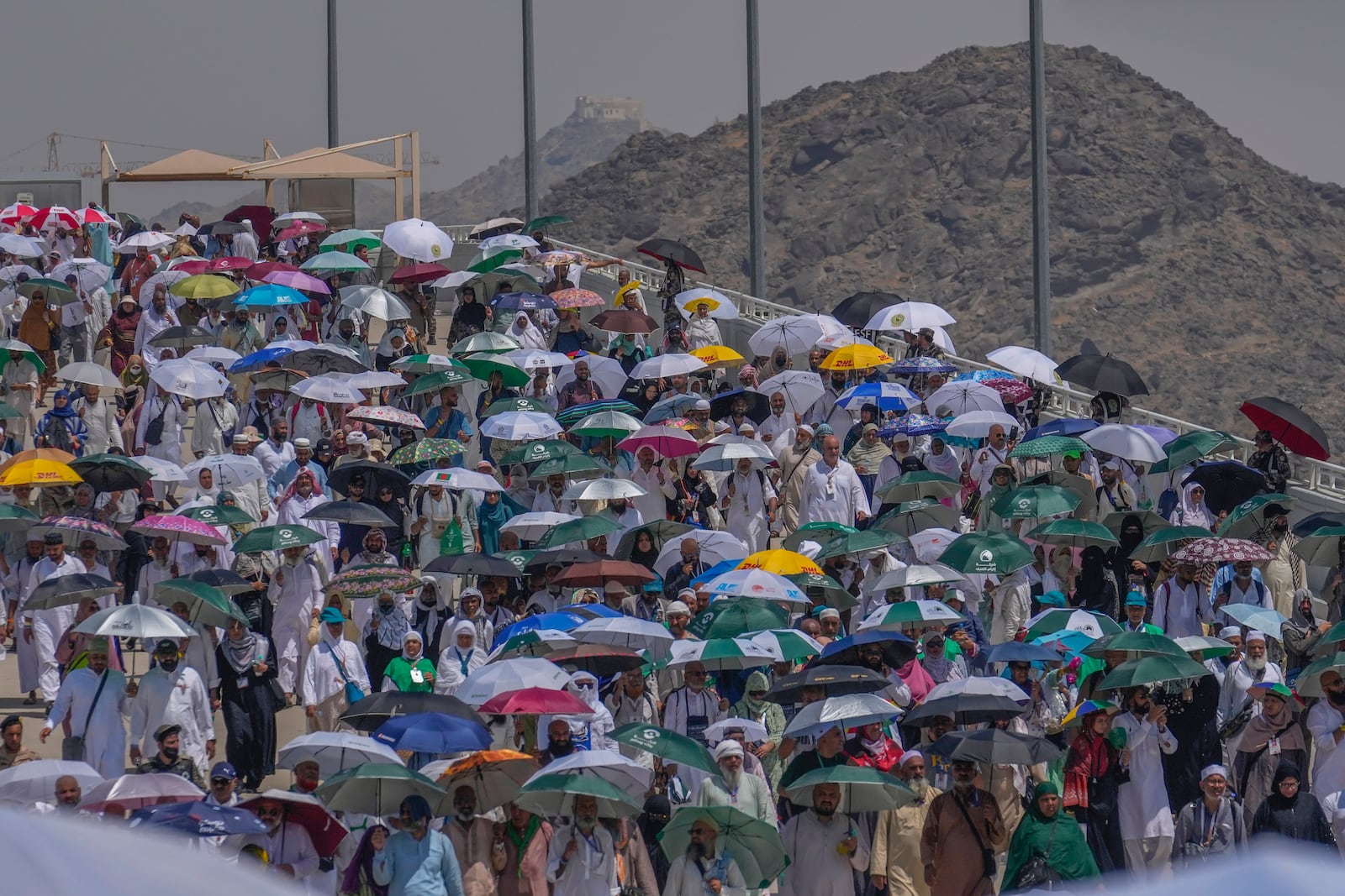 FILE - Muslim pilgrims use umbrellas to shield themselves from the sun as they arrive to cast stones at pillars in the symbolic stoning of the devil during the annual hajj, in Mina, near the holy city of Mecca, Saudi Arabia, Tuesday, June 18, 2024. (AP Photo/Rafiq Maqbool, File)
