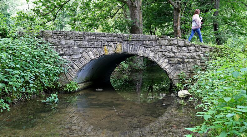 A woman walks across the old lower bridge at George Rogers Clark Park Monday. The bridge is in bad shape and ODOT will replace it next Summer. BILL LACKEY/STAFF