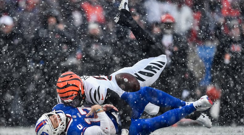 Buffalo Bills quarterback Josh Allen (17) takes a hit from Cincinnati Bengals defensive end Joseph Ossai (58) during the second quarter of an NFL division round football game, Sunday, Jan. 22, 2023, in Orchard Park, N.Y. The play was ruled an incomplete pass. (AP Photo/Adrian Kraus)