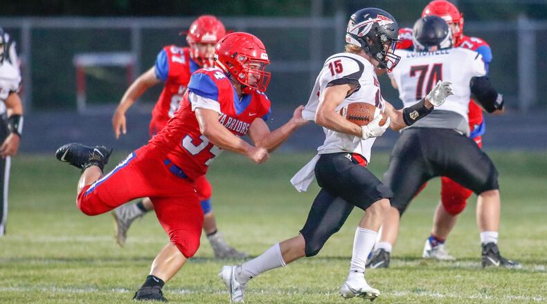 Northwestern High School senior John Angell grabs Indian Lake's Kaleb Hurley from behind during their game on Thursday night at Taylor Field in Springfield. Michael Cooper/CONTRIBUTED