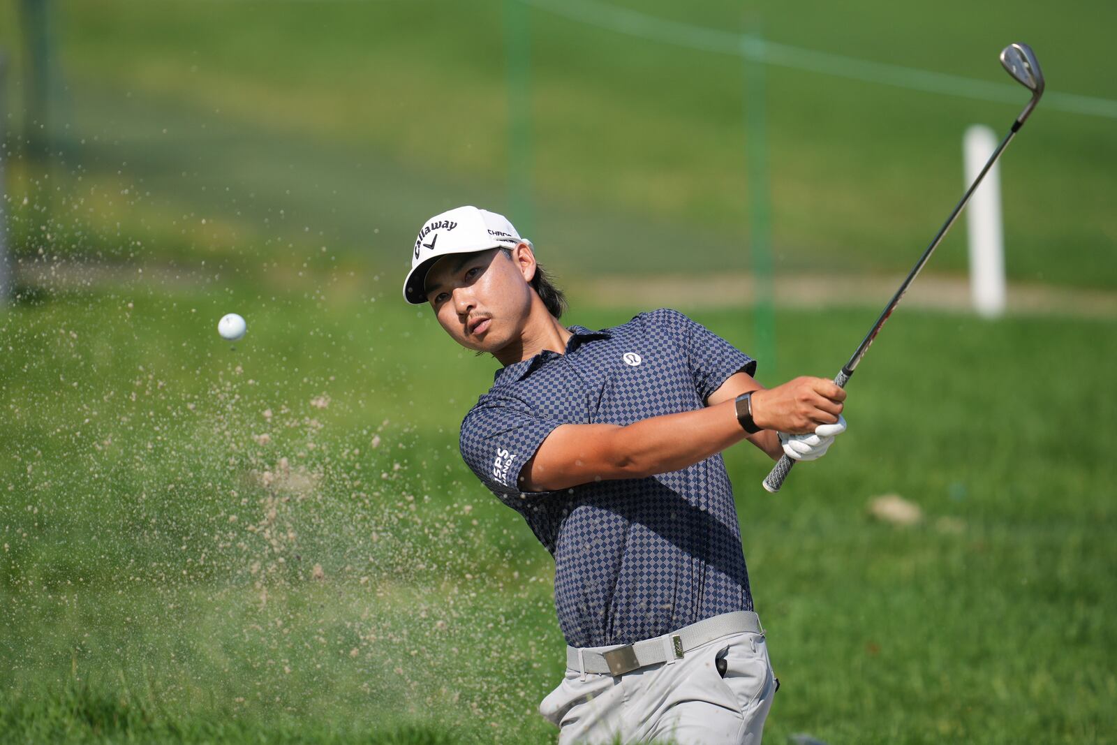 Min Woo Lee, of Australia, hits a bunker shot on the second hole during the first round of the Rocket Classic golf tournament at the Detroit Golf Club, Thursday, June 26, 2025, in Detroit. (AP Photo/Paul Sancya)