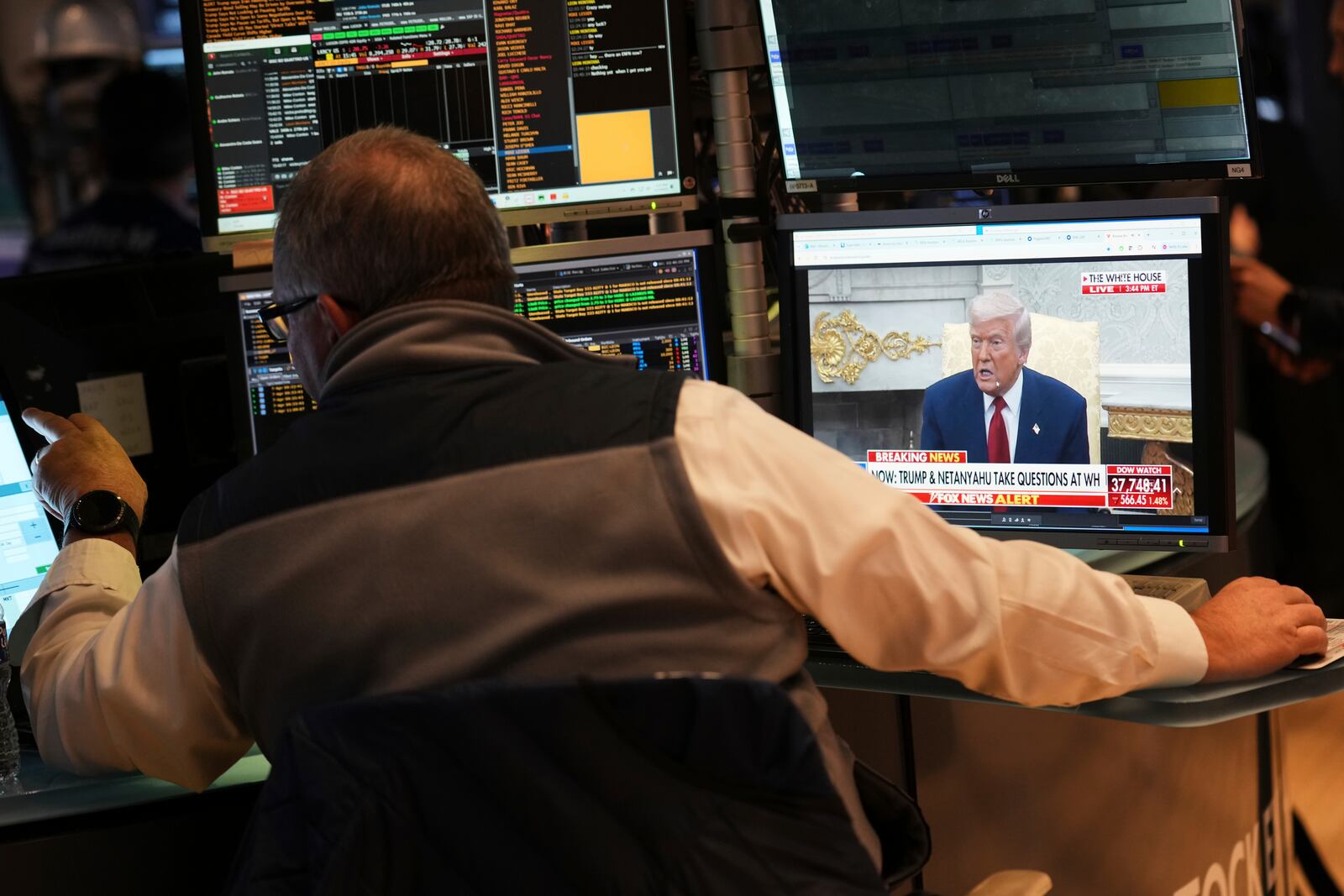 President Donald Trump is seen on the television as traders work on the floor at the New York Stock Exchange in New York, Monday, April 7, 2025. (AP Photo/Seth Wenig)